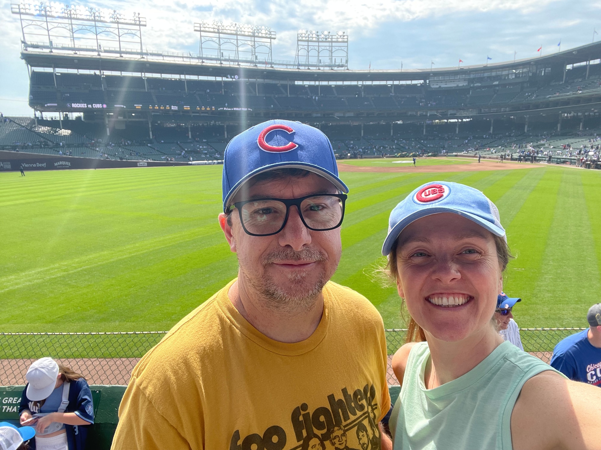 A man and woman at a baseball game wearing Chicago Cubs hats