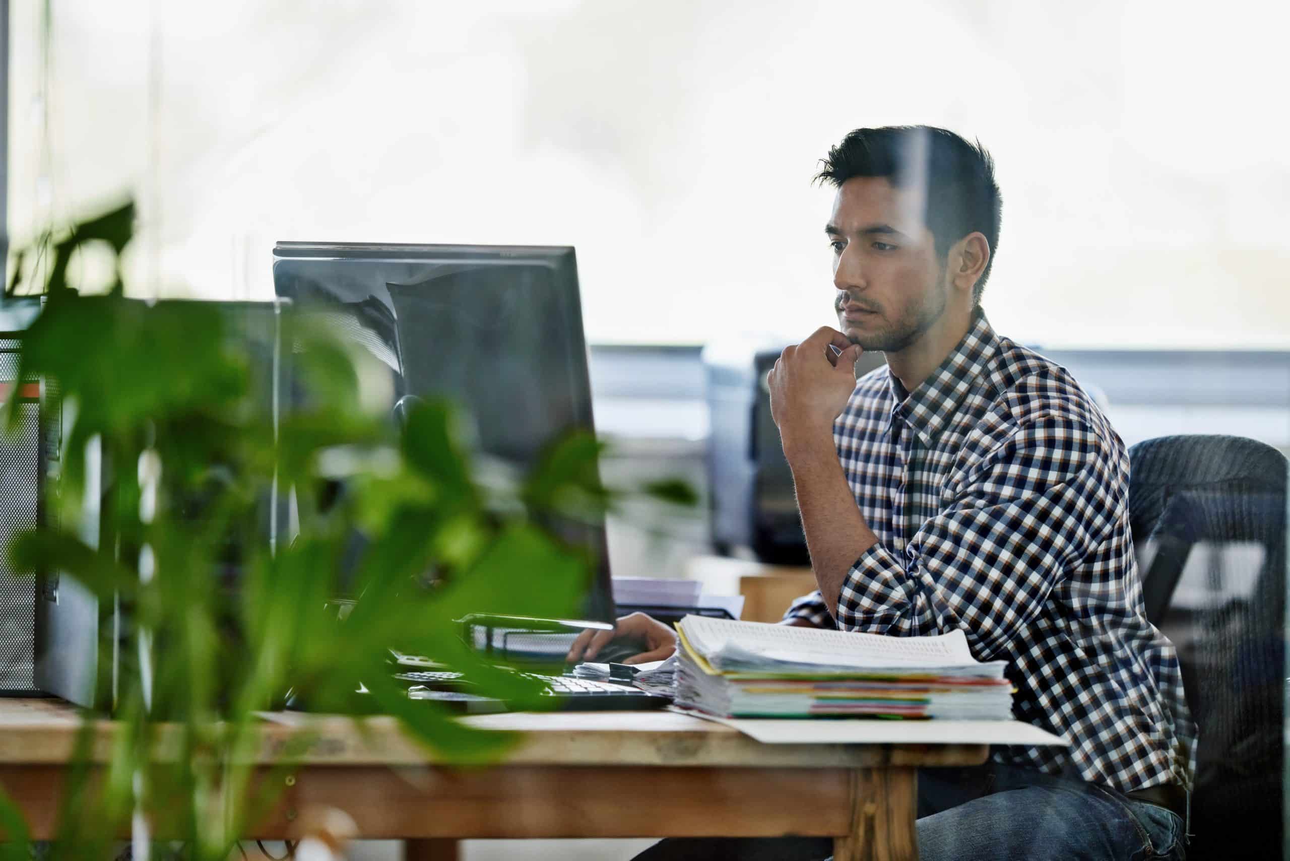 Businessman sitting at a computer coming up with a plan for clients