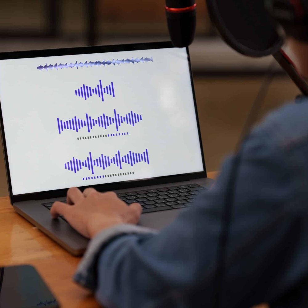 Podcaster editing audio podcast working at home studio.